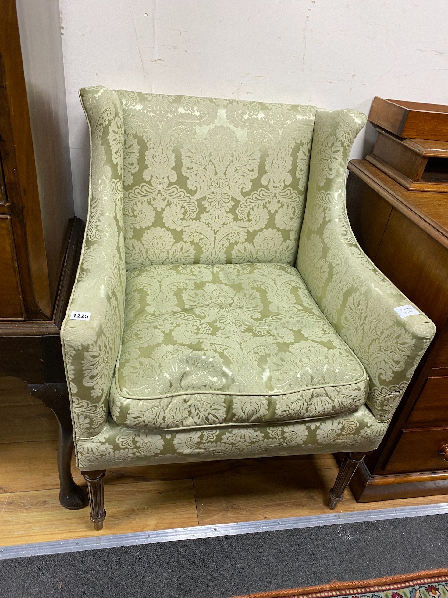 A small Edwardian mahogany upholstered wing armchair, covered in a pale green damask material, width 68cm, depth 65cm, height 90cm